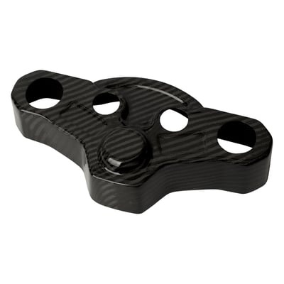 Woven, hand laid carbon. Made from a sheet of carbon fiber fabric woven in a crisscross pattern. Laid by hand into a mold, then cured in resin. The fabric layers are aligned in specific directions for strength. 

Carbon fiber triple tree top cover that fits over the stock top triple tree. Ultra light weight and manufactured from highest quality pure carbon fiber. For a clean, finished look when running handlebar risers instead of the stock bars. The look of true carbon fiber makes these covers a must have add-on for any performance orientated bike. Precisely shaped to bolt directly over the original triple tree top. Aligns with stock mounting points for a smooth and hassle-free installation without modifications. EU made. 
- Ultra light weight 
- Manufactured from top quality carbon fiber 
- Gloss surface with a clear coat UV stable finish 
- Bolt-on installation 

