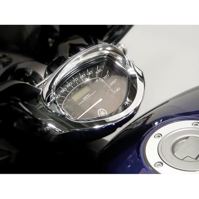 Attaches to tank-mounted speedometers. This half-mooned visor, made of cast metal, blocks the sun's glare from the speedometer glass to make it easier to read the speedometer. The visor has a quality chrome finish. It secures with a self adhesive tape.
